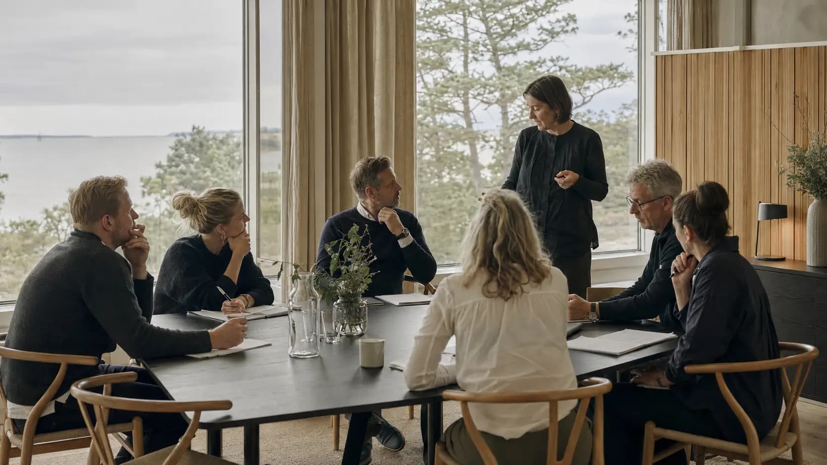Deltagere i et fysisk certificeringsforløb arbejder sammen omkring et kursusbord